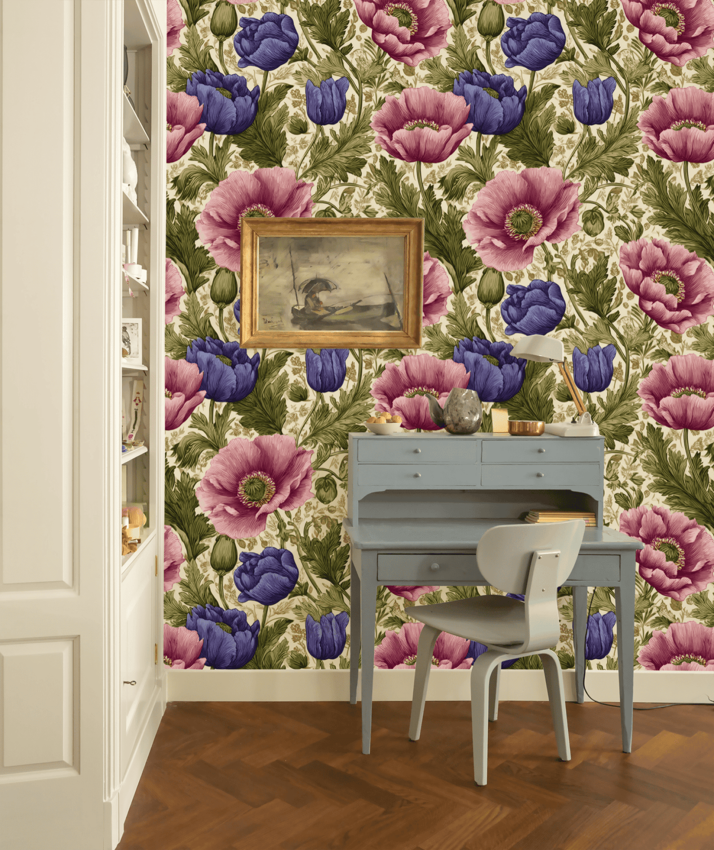 A small writing desk with a chair sits against a wall adorned with Blossom Reverie Wallpaper, its elegant blooming patterns complemented by a framed painting and decorative items above.