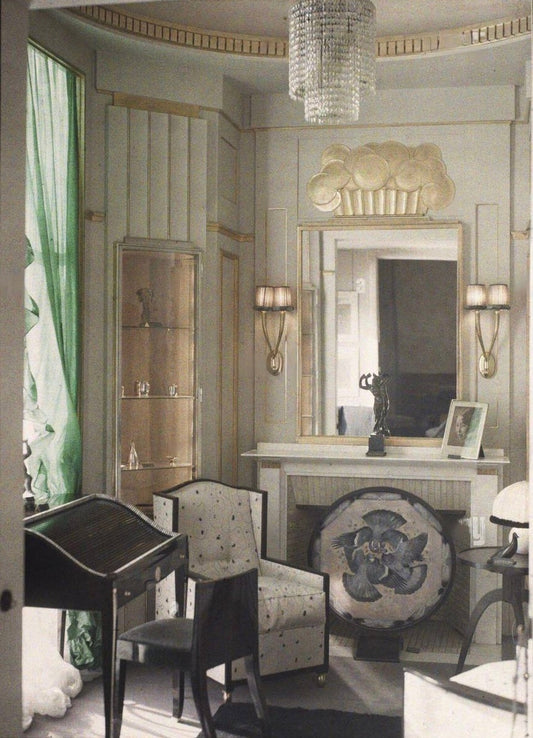 Art Deco interior showing chevron-pattern flooring, fan-back chairs, and gilded geometric wall decoration