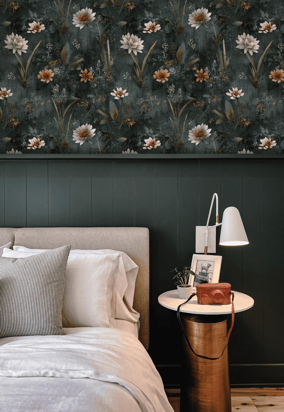 Bedroom with botanical wallpaper above a low upholstered headboard