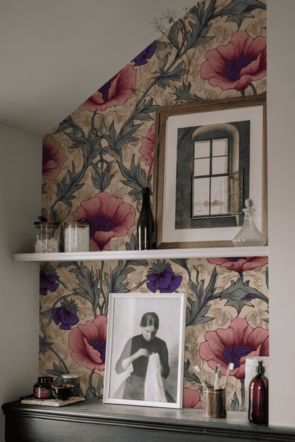A wall adorned with Blossom Reverie Wallpaper, two white shelves displaying framed art and decorative bottles, and a black dresser with a vintage portrait together evoke timeless elegance.