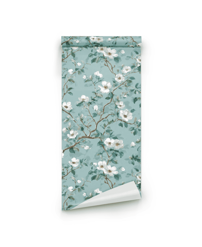 Blossom Whisper Wallpaper features a soft blue background adorned with white blossoms and lush green leaves in a delicate floral pattern.