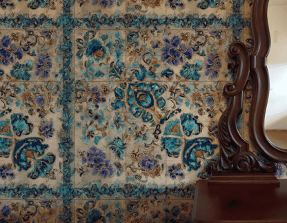 Elysian Mosaic Wallpaper in teal and gold floral patterns is showcased beside a dark wood-framed mirror, which partially reflects sunlight on a white wall.