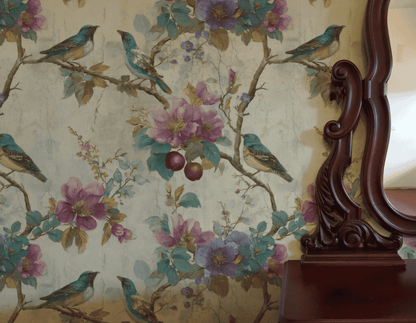 Charmed Haven Wallpaper featuring vivid birds and fruit is partially reflected in an ornate wooden mirror atop a wooden dresser, creating a serene ambiance.