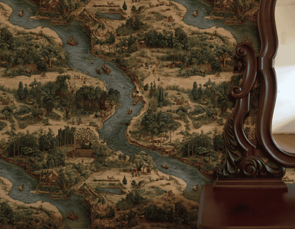 A vintage wooden mirror stands beside Riverside Tale Wallpaper, which features a whimsical landscape of flowing rivers, trees, boats, and small houses in muted colors.