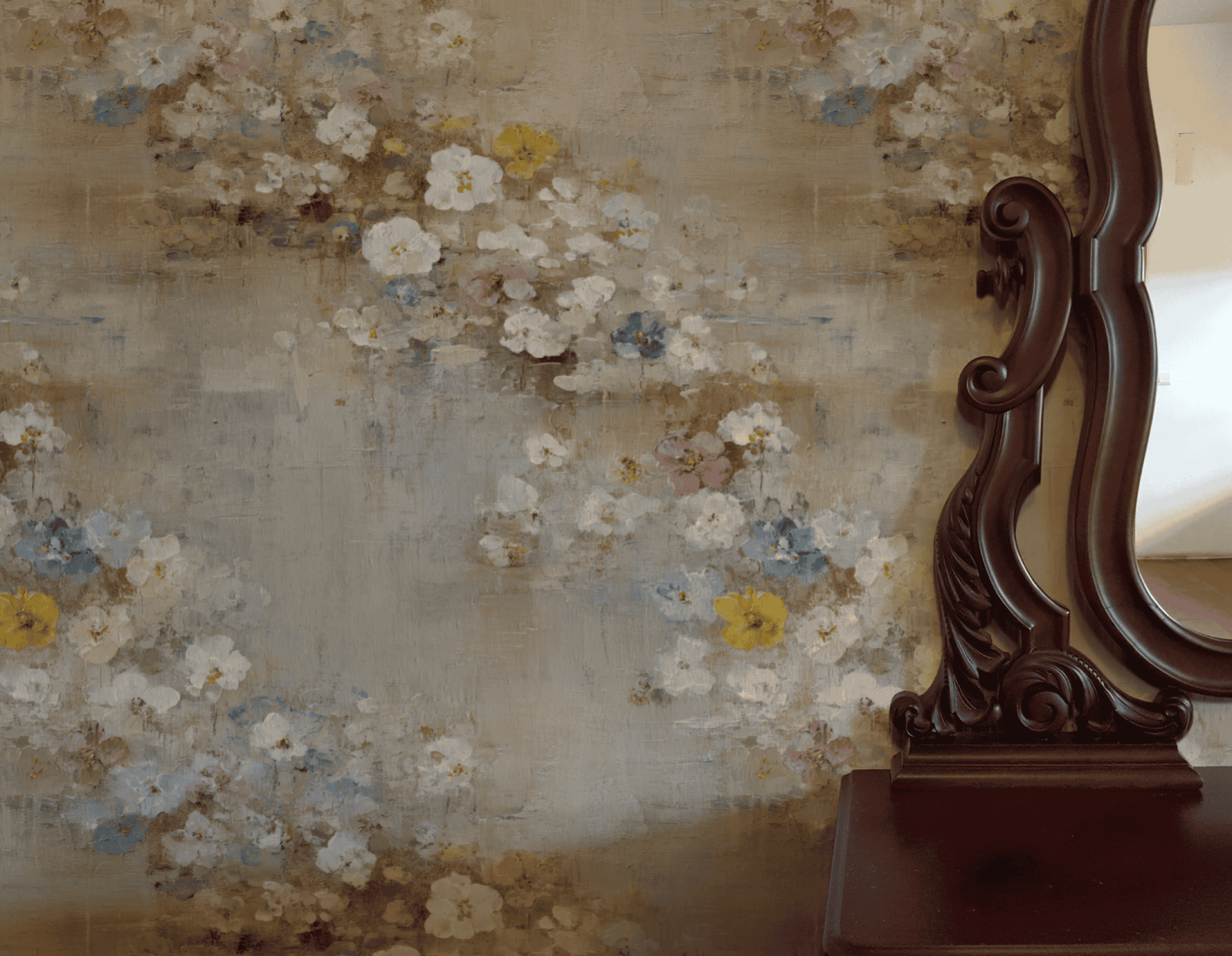 The Bloom Serenity Wallpaper, featuring soft floral tones, is displayed beside an ornate dark wood mirror that reflects a plain wall.