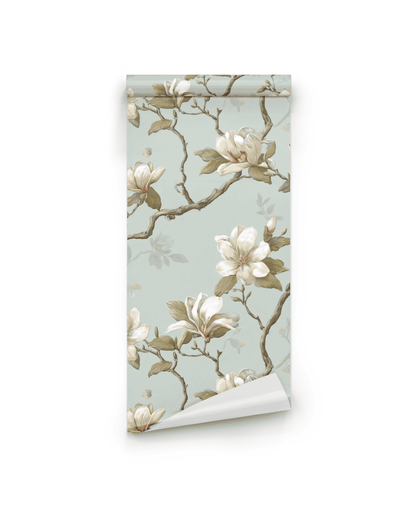 Magnolia Grace Wallpaper features a light blue background with magnolia flowers and brown branches, adding timeless elegance and natural charm to any room.