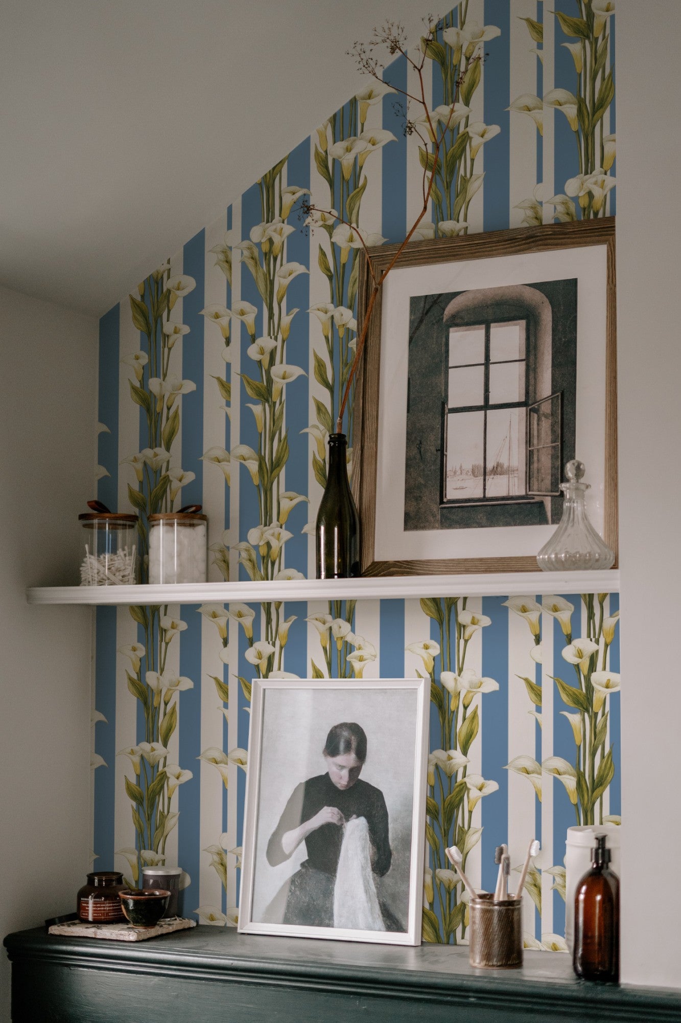 White calla lilies climbing a blue-and-white vertical cabana stripe in a fresh classic wallpaper. - room view