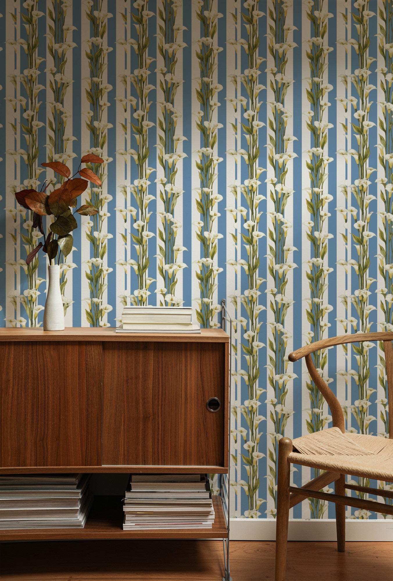 White calla lilies climbing a blue-and-white vertical cabana stripe in a fresh classic wallpaper. - room view