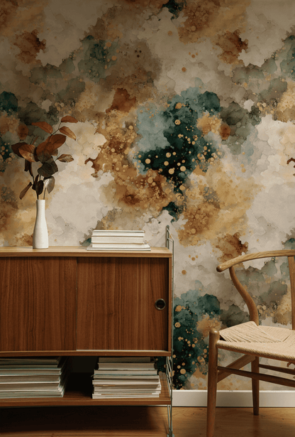 A wooden cabinet with books and a vase of brown foliage sits beside a woven chair, set against the Ethereal Splatter Wallpaper for an air of organic tranquility.