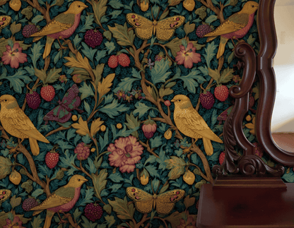 The Enchanted Garden Wallpaper showcases yellow birds and butterflies among vibrant flowers and berries, with part of a wooden mirror frame visible on the right.