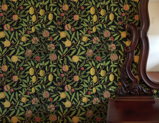 Black Botanical Wallpaper installed in a room interior with the Morris dark fruit and pomegranate design in dark botanical Victorian palette