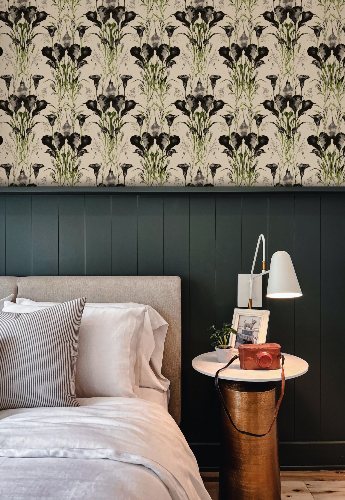 Symmetrical black-ink calla lilies and grasses with green accents on a cream ground in a dramatic wallpaper. - room view
