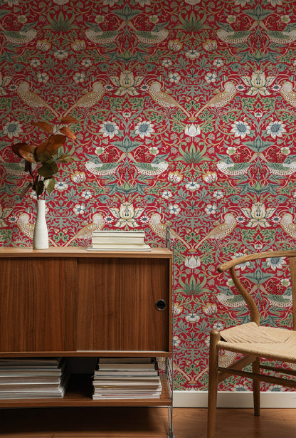 Red Bird Pattern Wallpaper installed on a room wall with the iconic 1883 Morris thrushes-among-strawberries design in deep heritage red