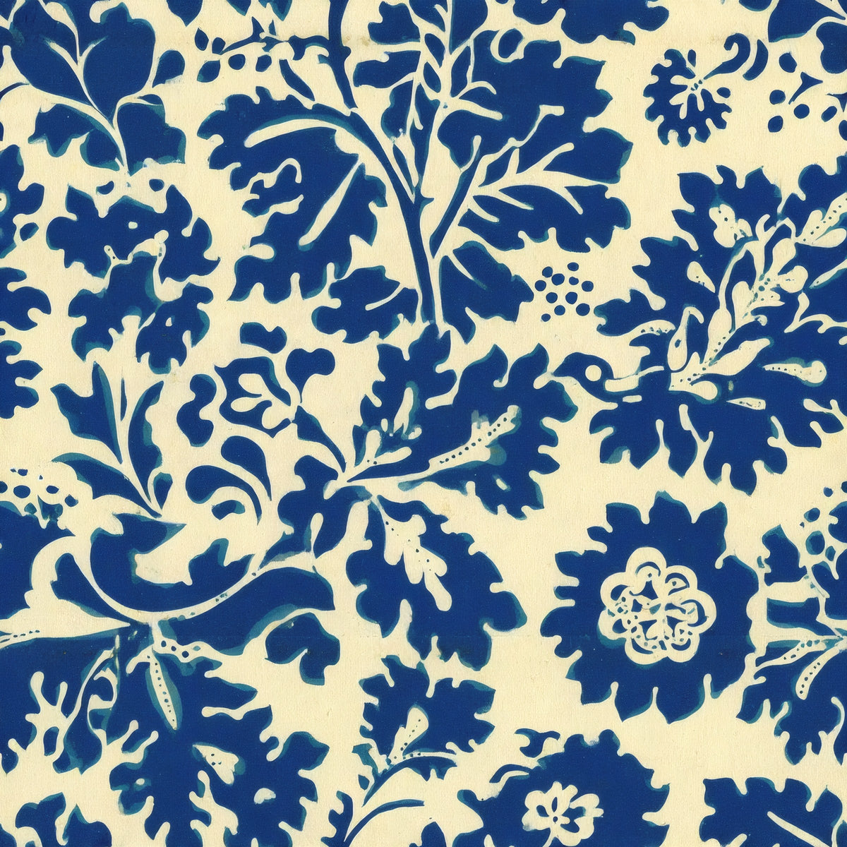 Bold indigo leaves and flowers in a single-colour print on a warm cream ground, a William Morris design.