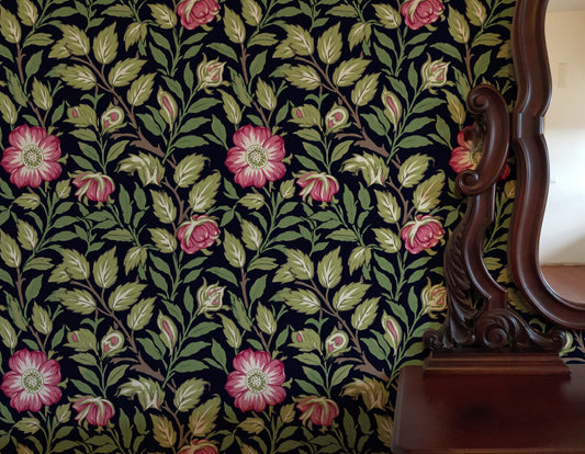 Green Floral Wallpaper installed in a room interior with the Morris sweet briar rose design in dark botanical tones